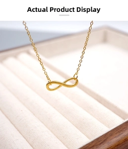 Macro detail of golden infinity pendant on a thin chain over a soft velvet jewelry box