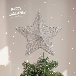 Silver glitter star Christmas tree topper with spring base on a green pine tree