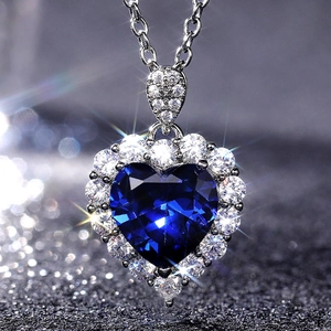 Blue heart pendant necklace with sapphire-like stone and silver halo setting