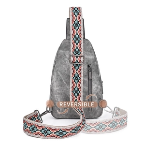 Gray textured sling bag featuring a reversible wide ethnic style embroidered strap