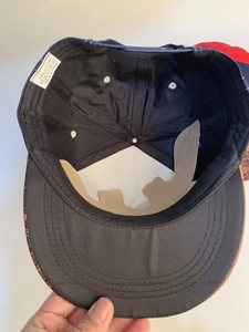 Internal detail of a 100% cotton baseball cap showing 6-panel structure and washing label