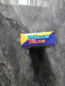 Top view of two-pack kids walkie talkie toy packaging box on marble floor surface