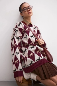 Detail of round neck knitted sweater featuring horse silhouette and argyle pattern