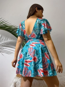 Detail view of backless tropical print swimsuit with ruffled sleeves and leaf patterns
