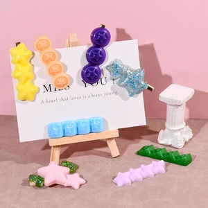 Star and round resin hair clips in vibrant colors displayed on a mini easel stand