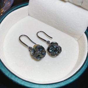 Gros plan de boucles d'oreilles vintage en cristal bleu foncé avec crochets en métal noir