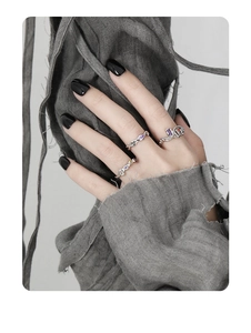 Detail of S925 silver chain rings set with purple and yellow zircons on hand
