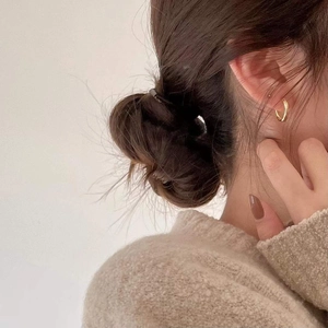 Close-up of minimalist gold twisted rope hoop earrings on a model showing side profile