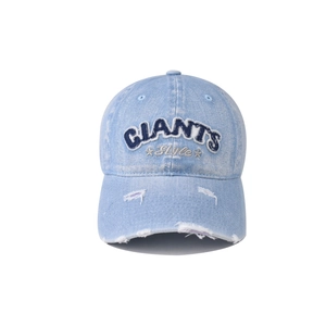 Close-up of embroidered Giants text and distressed details on light blue denim baseball cap