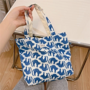 Detailed close-up of a blue cat pattern cotton tote bag with Simple Wish label