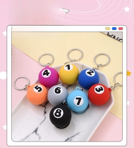 Detailed set of eight colorful miniature billiard ball keychains in a white tray