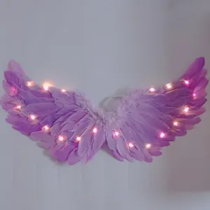 Dettaglio di ali d'angelo viola piumate con luci LED rosa brillanti e piume morbide