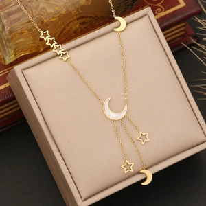 Detail of gold star and moon layered necklace on a jewelry box with vintage book
