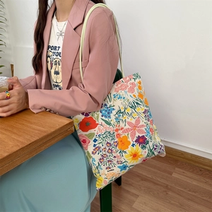 Sac fourre-tout en toile à fleurs avec poignées vertes dans un café décontracté