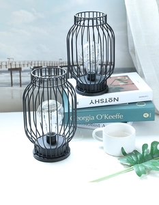 Detail of minimalist black iron lantern lamps with LED Edison bulbs on a modern desk