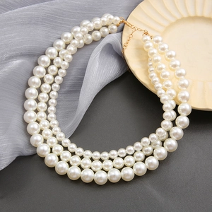 Elegant triple-layered white faux pearl necklace with adjustable gold metal clasp on silk