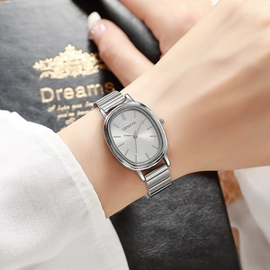 Macro detail of silver oval quartz watch with elegant metallic bamboo-style link strap