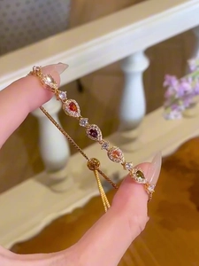 Detail showing colorful teardrop-cut zircon stones on a gold adjustable slider bracelet