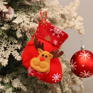 Detail of red felt Christmas stocking featuring reindeer doll and snowflake embroidery