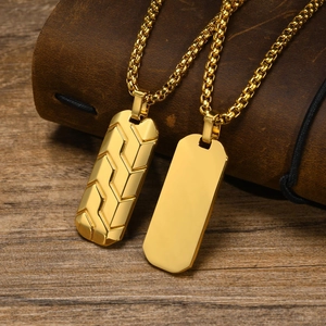Detailed view of men's gold dog tag necklaces with geometric tire texture on leather
