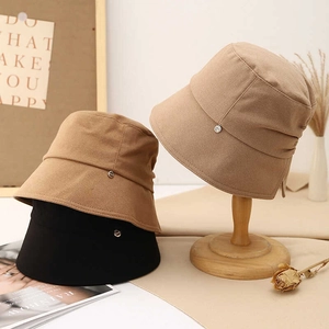 Detail view of cotton sun hats featuring a metallic accent and elegant bow decoration
