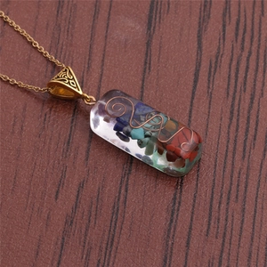 Detailed close-up of a resin pendant necklace with colorful stones and wire wrapping