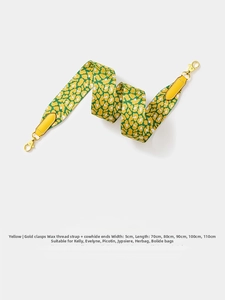 Detailed view of 5cm wide leopard print webbing strap with yellow leather ends and gold hooks