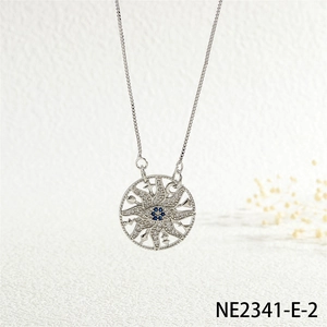 Close-up of silver sun pendant necklace with blue center stone and white zircons