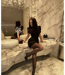 Side view of a sexy black mini dress with puff sleeves and A-line cut worn by a model