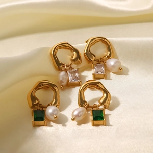 Boucles d'oreilles vintage en or avec zircon vert et perles gouttes sur soie beige