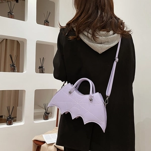 Detail of purple bat-shaped PU leather crossbody bag with embroidered spider web pattern