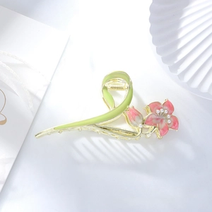 Detailed view of enamel gardenia flower hair claw clip with pearls on golden metal base