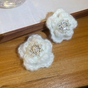 Gros plan détaillé d'une pince à cheveux fleur tricotée avec perle et strass centraux