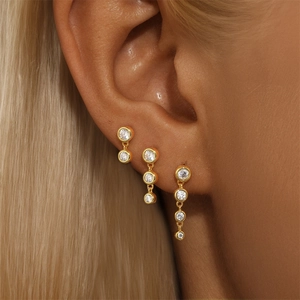 Macro shot of gold zircon earring set showing elegant drop and leaf style on ear
