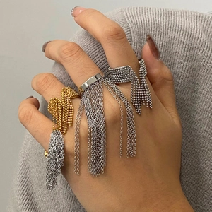 Three gold and silver stainless steel tassel rings featuring chain link fringe on grey background