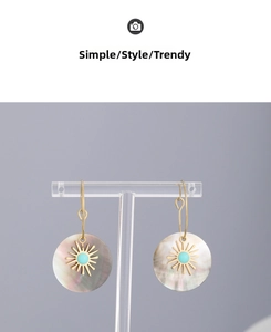 Macro detail of sunburst drop earrings with turquoise stone and iridescent shell inlay