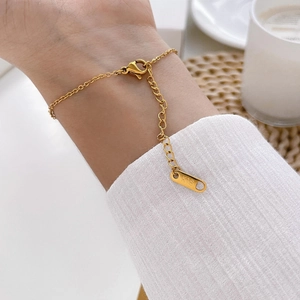 Close-up of gold chain bracelet with K18 engraving on tag and secure lobster clasp