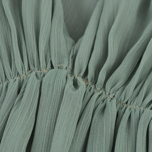 Detailansicht von salbeigrünem Falten-Chiffon-Stoff mit feiner Textur und Nähten