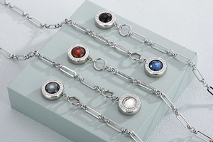 Close-up of five silver chain necklaces with colorful rhinestone pendant variations