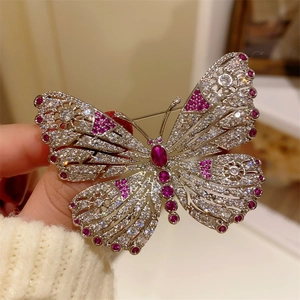Elegant butterfly brooch with pink ruby accents and sparkling zircons on silver metal