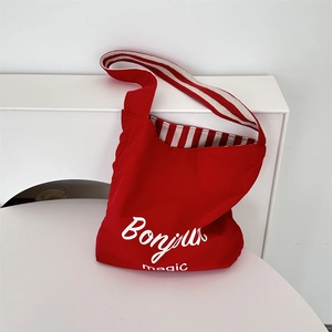 Detail of red canvas tote bag with Bonjour print and red-white striped interior lining