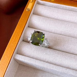 Green square zircon ring with pear-cut side stones in a silver four-prong setting