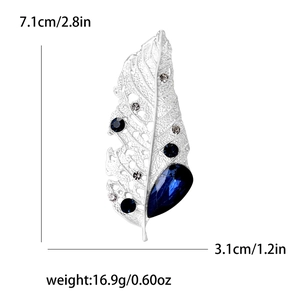Silver leaf brooch with blue gems and rhinestones showing size 7.1cm x 3.1cm and 16.9g weight