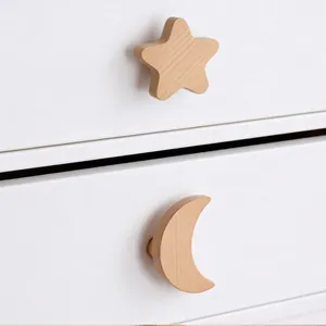 Nordic solid wood star and moon hooks installed on white drawer handles in natural wood finish