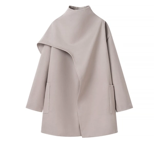 Detail of grey wool coat featuring asymmetric shawl collar and diagonal side pockets