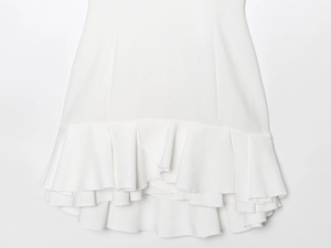 Detail shot of white tiered ruffle hem and fine fabric texture on halter mini dress