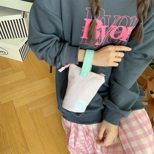 Close-up of portable pink striped pencil case with mint green snap button handle