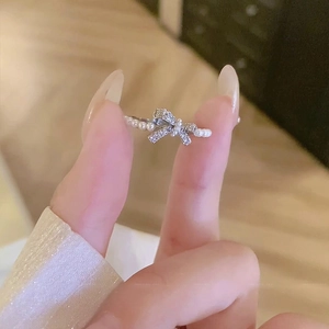 Detail of cubic zirconia bow ring with white pearls and adjustable silver band