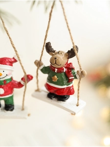 Macro shot of resin reindeer and snowman ornaments on a wood swing with Christmas bokeh