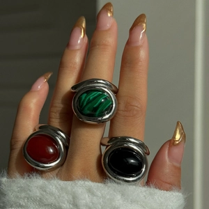 Close-up of vintage 18k gold plated gemstone rings with malachite on a model's hand